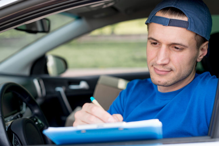 A male test driver holding a paper