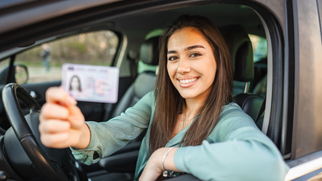 Une jeune fille tenant son permis de conduire.